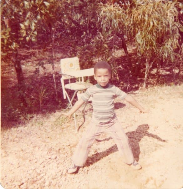 Steven as a boy, striking a pose in the yard in Jamaica